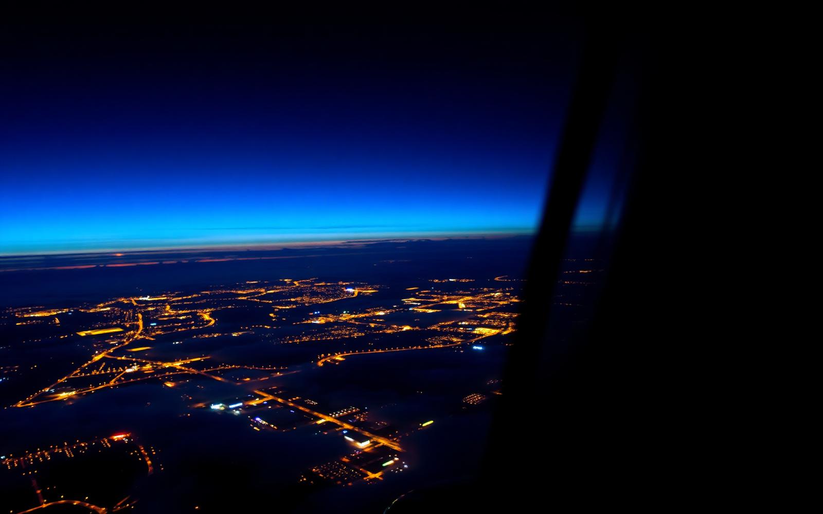 Vista do mundo pela janela do avião ao entardecer